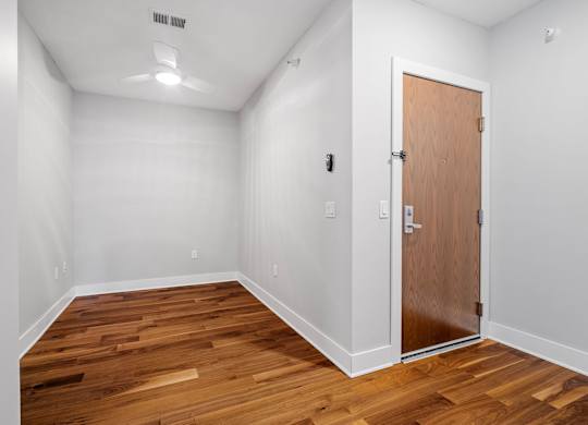 a bedroom with wood flooring and a door to a closet