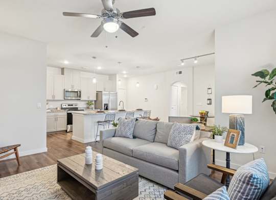 A living room with a grey couch and a wooden coffee table.