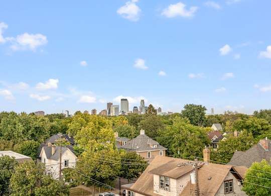 A city skyline is visible in the distance behind a row of houses.