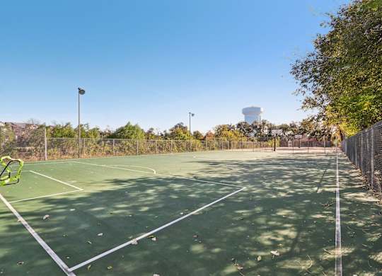 A tennis court with a net and a water tower in the background.
