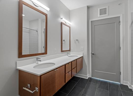 A bathroom with a sink, mirror, and wooden cabinets.