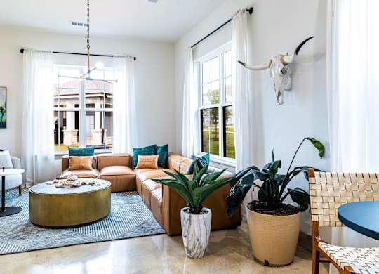 A living room with a large couch, a coffee table, and a rug.