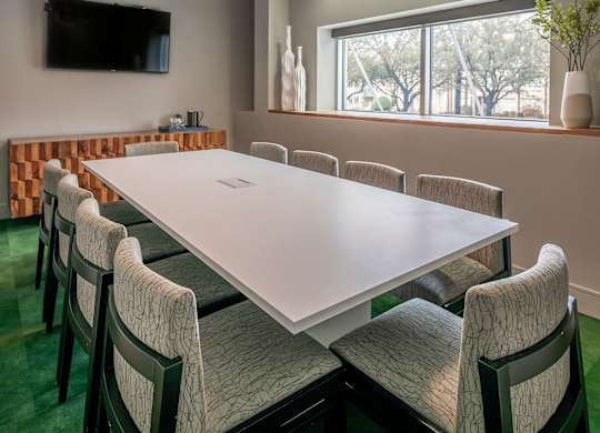 A conference room with a long table and chairs.