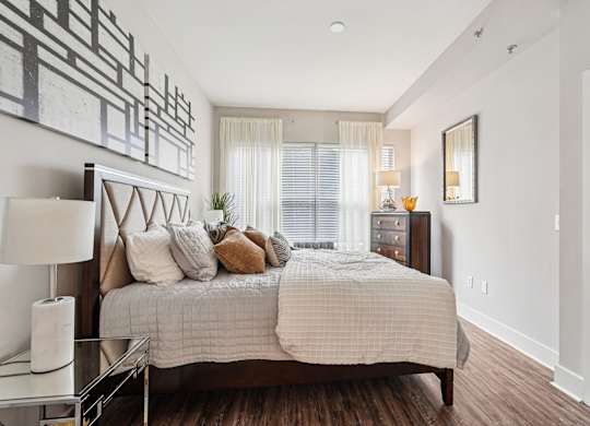 A bedroom with a large bed and a painting on the wall.