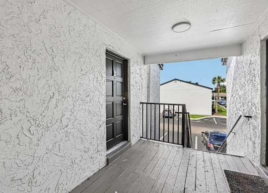 A balcony with a black railing and a wooden floor.