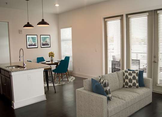 A modern kitchen with a dining table and a couch.