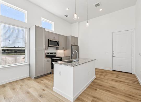 A kitchen with a sink, stove, and refrigerator.