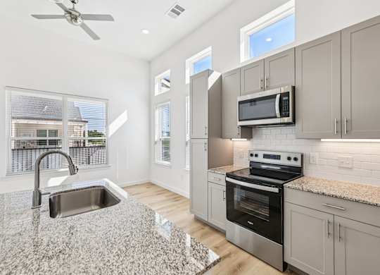 A modern kitchen with granite countertops and stainless steel appliances.