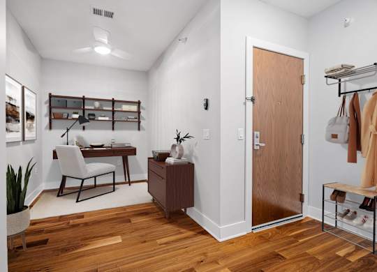 A room with a desk, chair, and shelves.