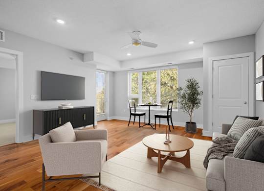 A living room with a grey couch, a wooden coffee table, and a television.