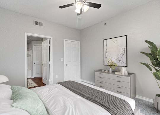 an empty bedroom with a bed and a ceiling fan