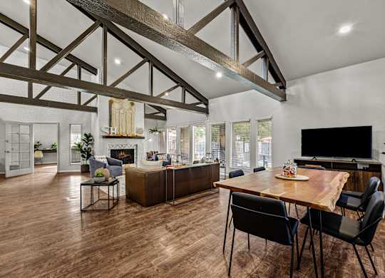 a living room with a dining room table and a tv