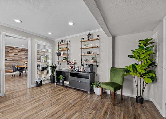 a living room with white walls and wood floors and a black entertainment center