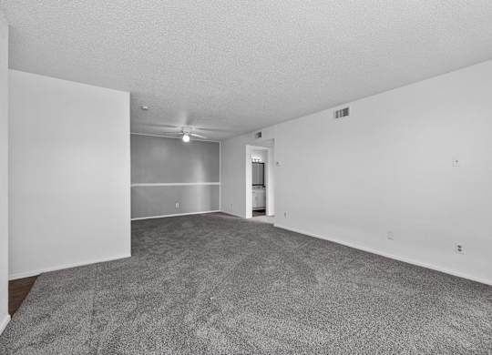 an empty living room with carpet and white walls