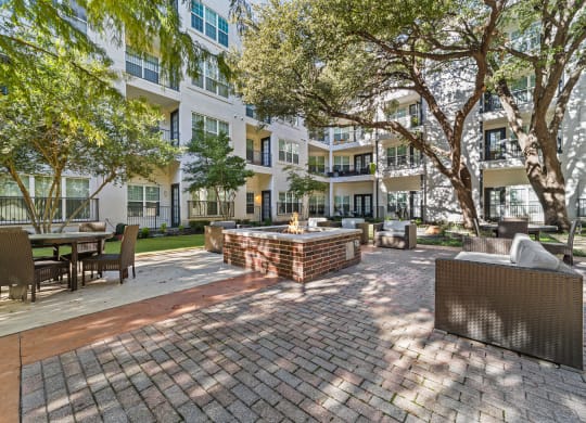 a courtyard with a fountain and tables and chairs in front of an apartment building