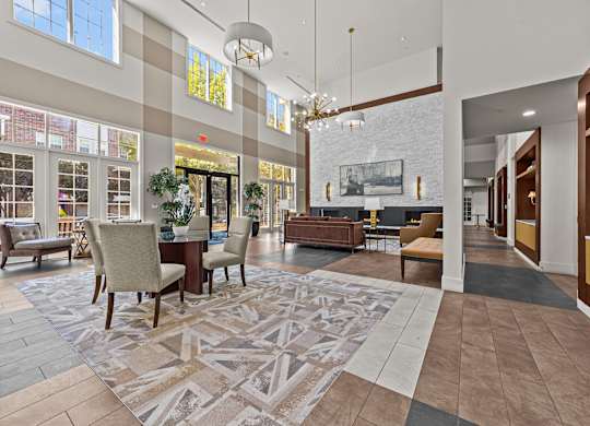 a large lobby with chairs and tables and a fireplace