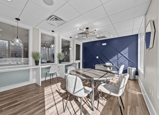 a dining room with a table and chairs and a blue accent wall