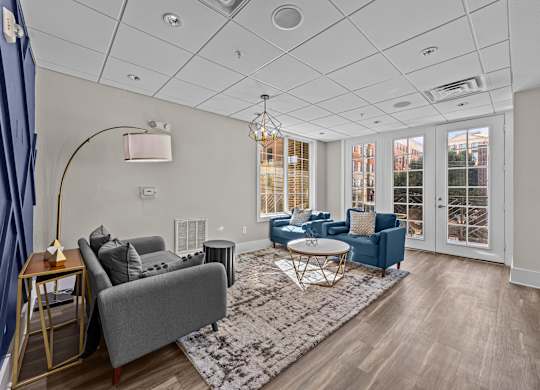 a living room with couches and chairs and a rug