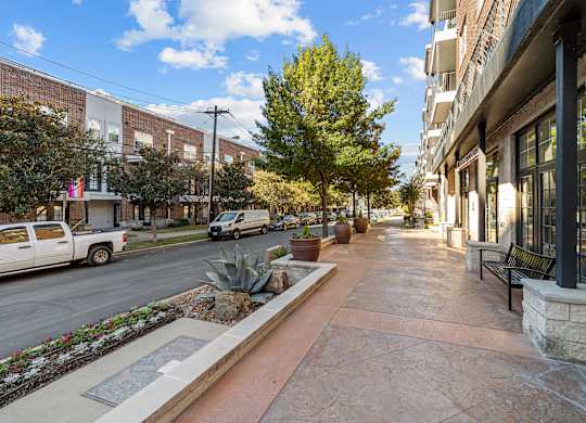an empty sidewalk in front of a building on a city street