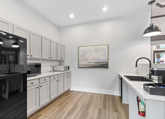 a kitchen with white cabinets and black appliances and a black refrigerator