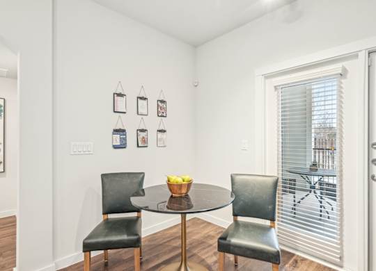 A dining room with a table and two chairs.