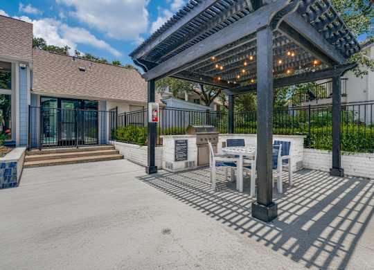A patio with a pergola and outdoor furniture.