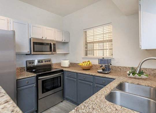 a kitchen with stainless steel appliances and granite counter tops
