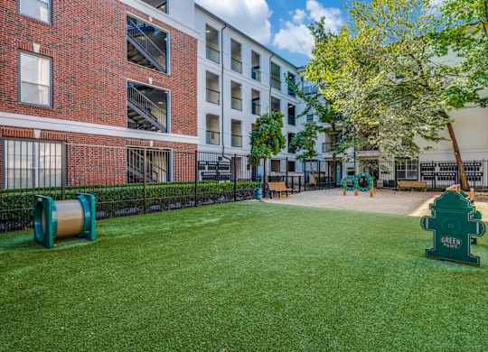 our apartments have a large yard with green grass and a fire hydrant