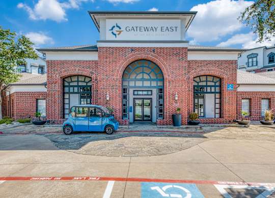 the exterior of the gateway east building with a blue car parked in front of it