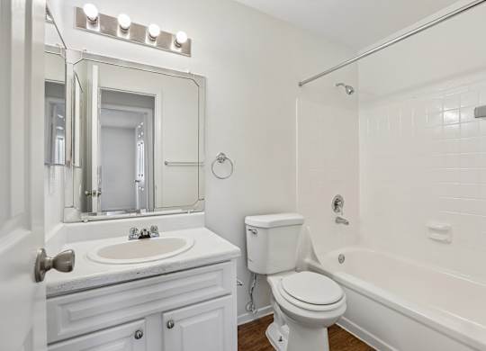 A white bathroom with a sink, toilet, and bathtub.