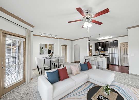 A living room with a white couch and a ceiling fan.