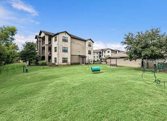 A large grassy area in front of apartment buildings.