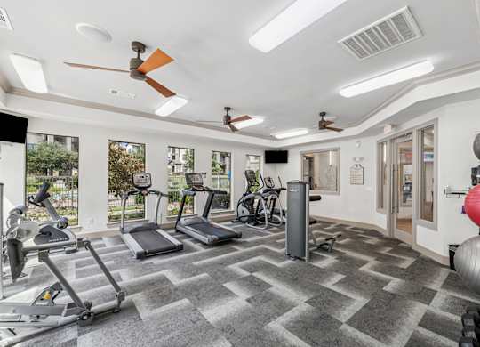 A spacious gym with treadmills, elliptical machines, and other exercise equipment.