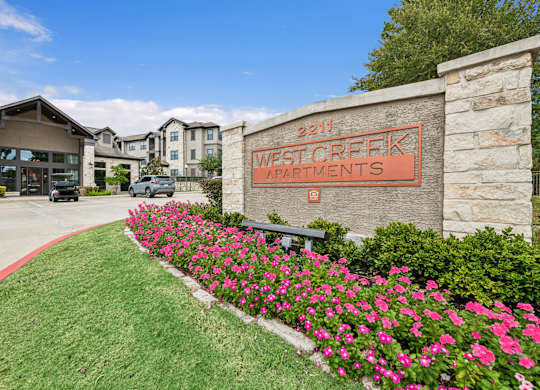 West Creek Apartments is a beautiful apartment complex with a well-maintained garden in front.