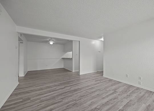 A room with wooden flooring and white walls.