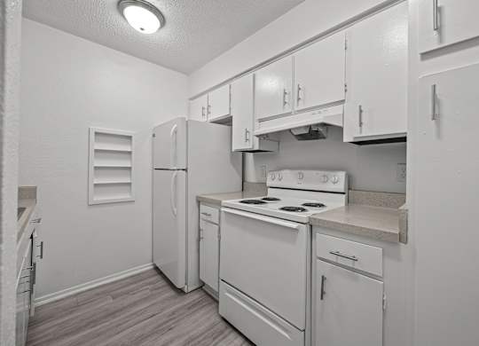 A kitchen with white appliances and cabinets.