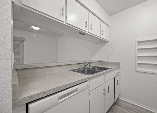 A kitchen with white cabinets and a countertop.