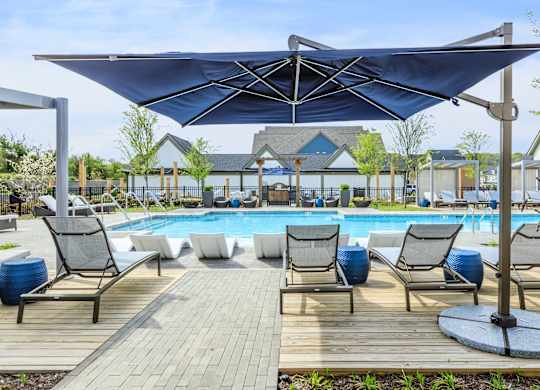 A pool area with a canopy and lounge chairs.