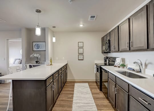 A modern kitchen with dark wood cabinets and white countertops.