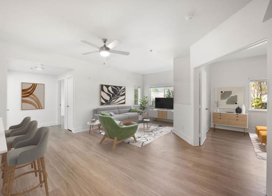 a living room with white walls and a ceiling fan