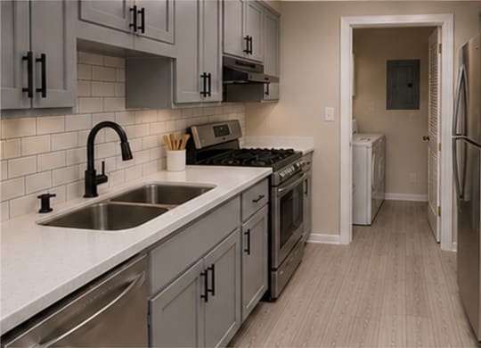 A kitchen with a refrigerator, sink, and cabinets.
