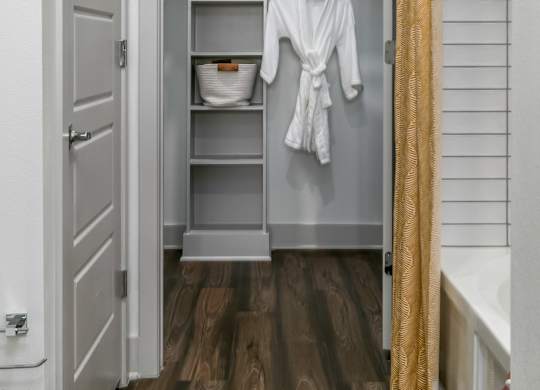 A white bathroom with a white towel hanging on a rack.