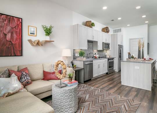 A modern kitchen with a dining table and a couch with a wreath on it.