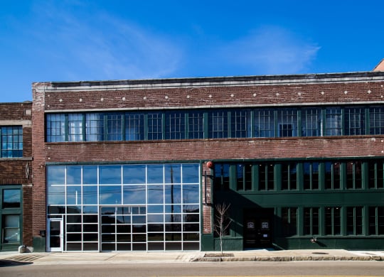 photo of the front of a red brick building with large windows