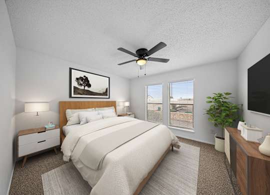 A bedroom with a large bed, a ceiling fan, and a painting on the wall.
