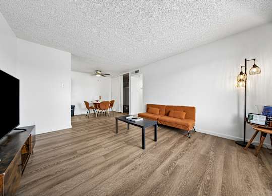 A living room with a brown couch and a wooden coffee table.