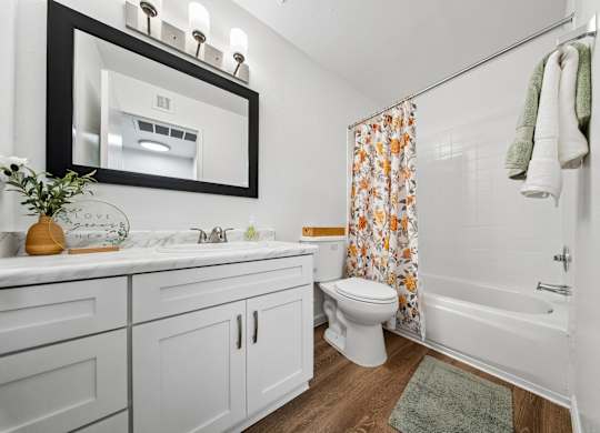 A white bathroom with a toilet, sink, and shower.