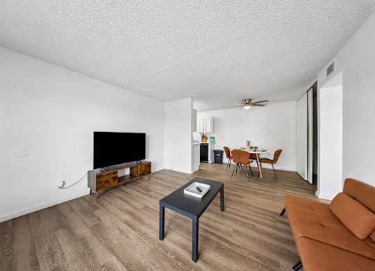 A living room with a brown couch and a black coffee table.