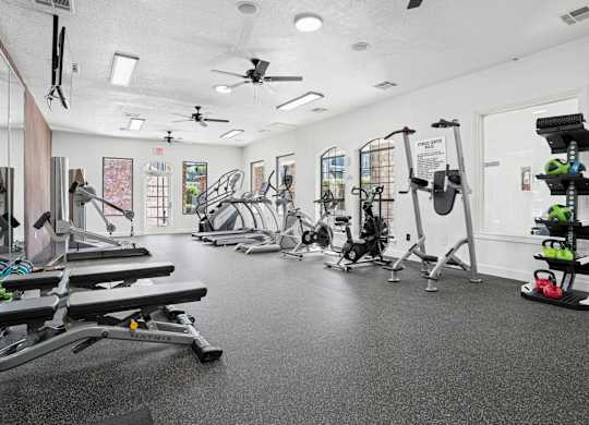 A spacious gym with a variety of equipment including treadmills, weights, and exercise machines.
