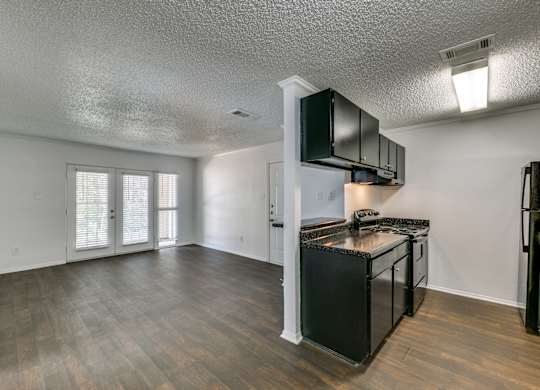 the living room and kitchen of an empty apartment with a stove and refrigerator